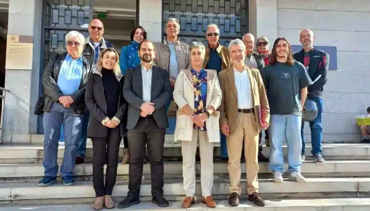 Grupo de pessoas sorridentes em degraus ao ar livre.