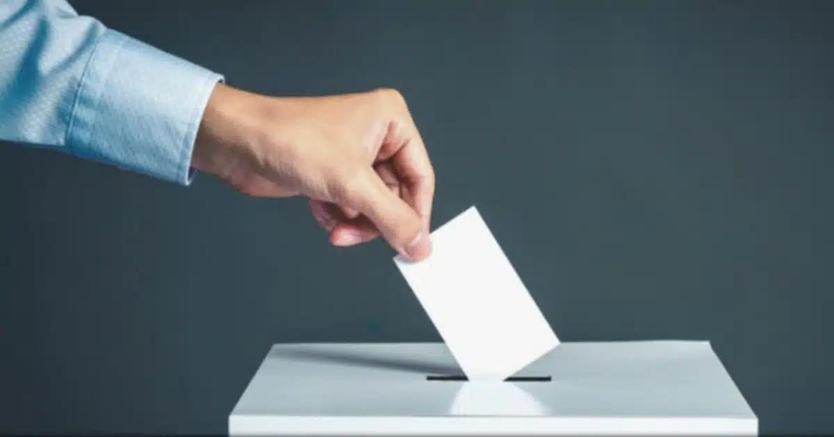Voto sendo depositado em urna eleitoral.